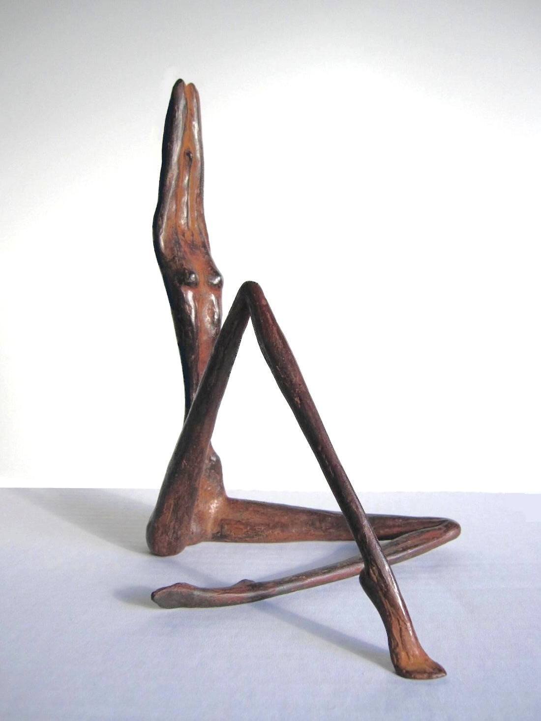 bronzen beelden van beeldhouwer Ragonda IJtsma, een vrouwenbeeldje, rank, slank, gestileerd en bijna abstract brons Bronzen beeldje, vrouwenfiguur, zittende vrouw
